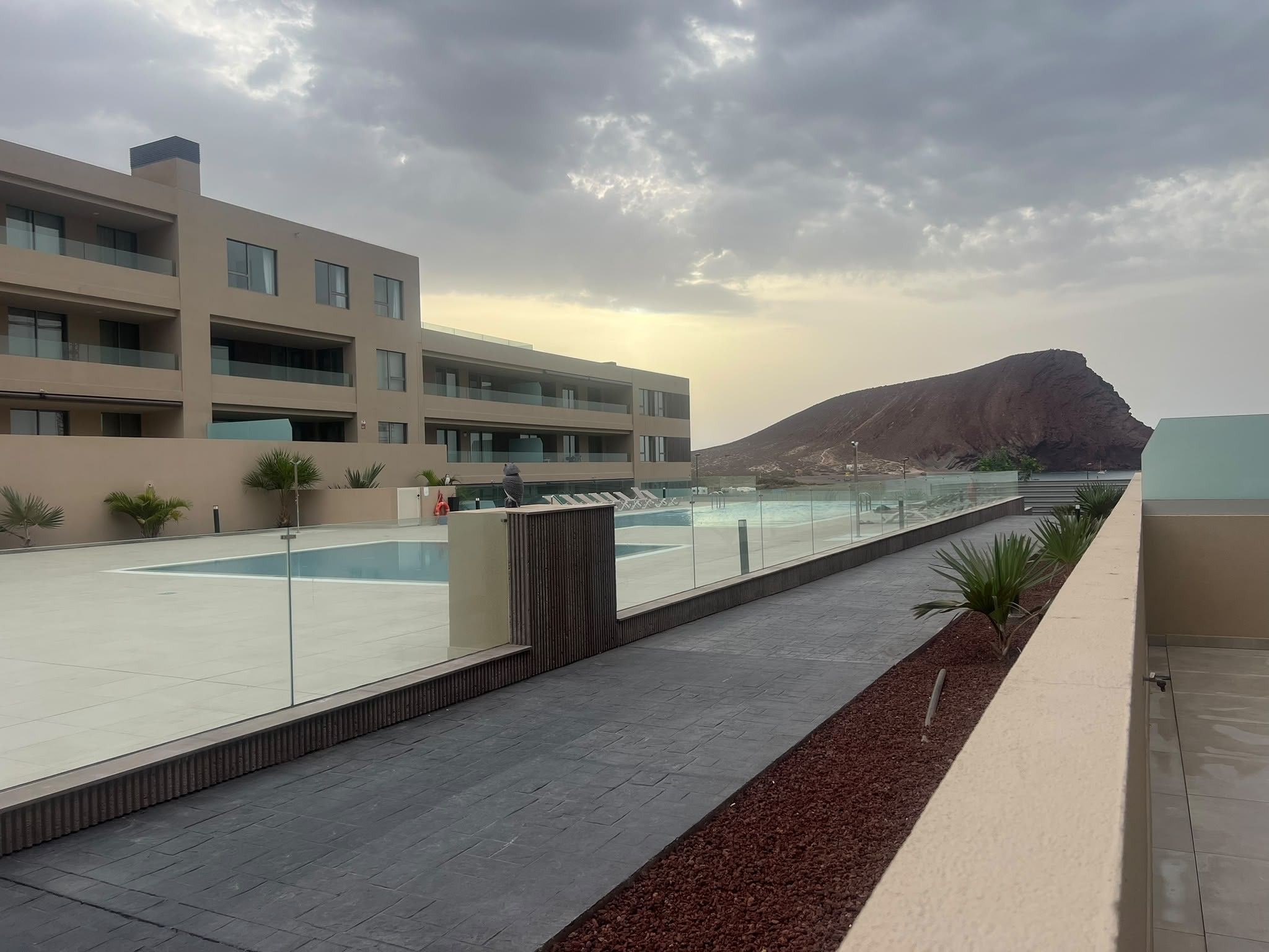 Un hôtel moderne doté d’une piscine, d’un espace extérieur aménagé et offrant une vue sur les montagnes.
