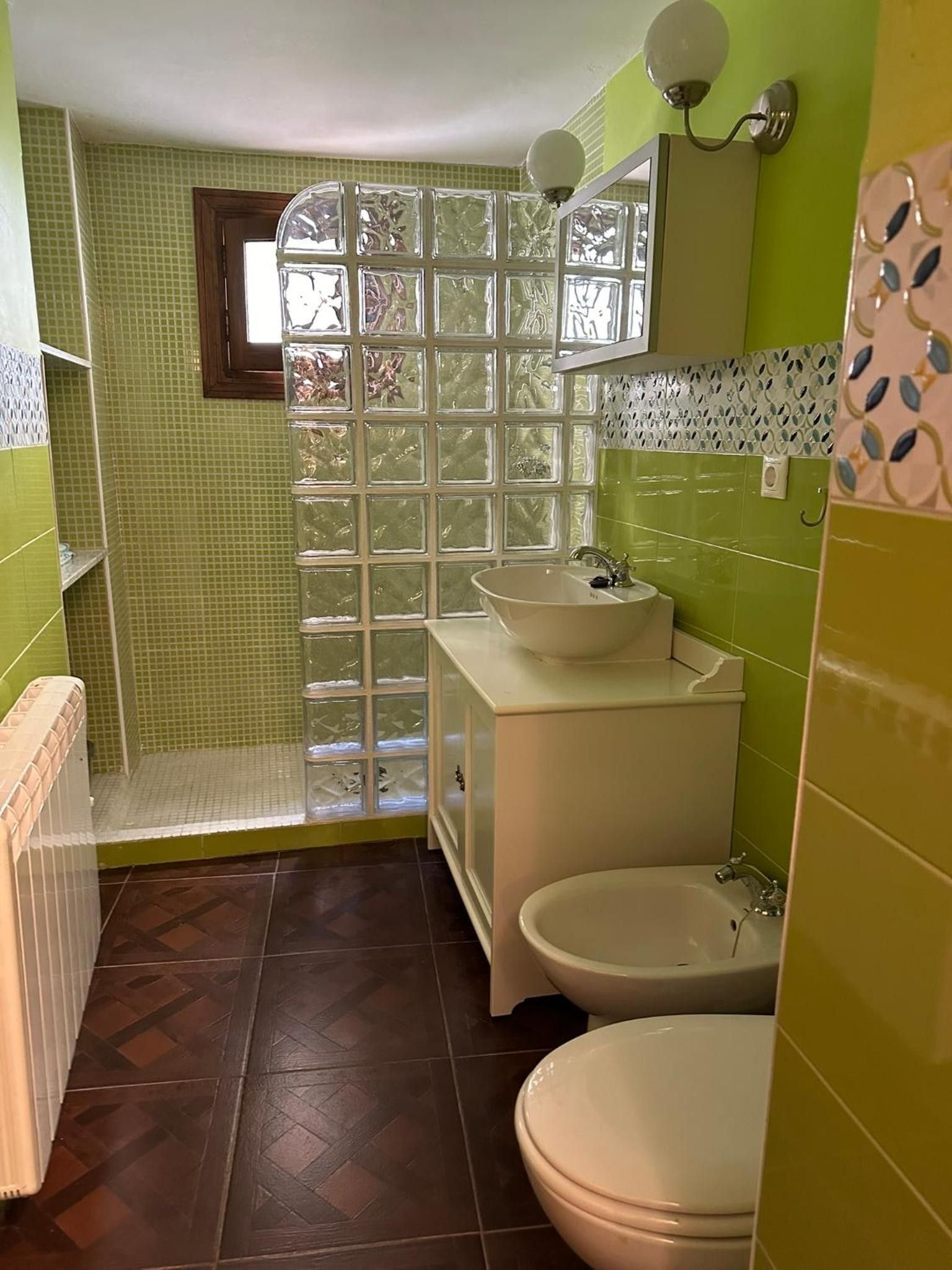 Un baño con ducha, dos lavamanos, inodoro y bidé.