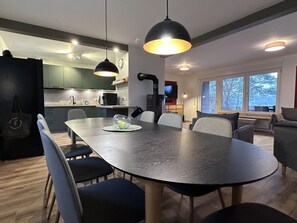 A modern kitchen with a dining area, a black refrigerator, and a large window. - Time out at Lake Lanzer (Basedow)