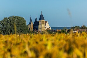 A historic church with multiple spires, surrounded by a field of tall grass.