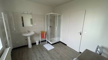 Une salle de bain moderne avec un lavabo, un miroir et une douche à parois de verre.