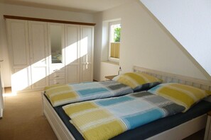 A bedroom with a bed, a wardrobe, and a window. - Holiday home Ellerau (Ellerau)