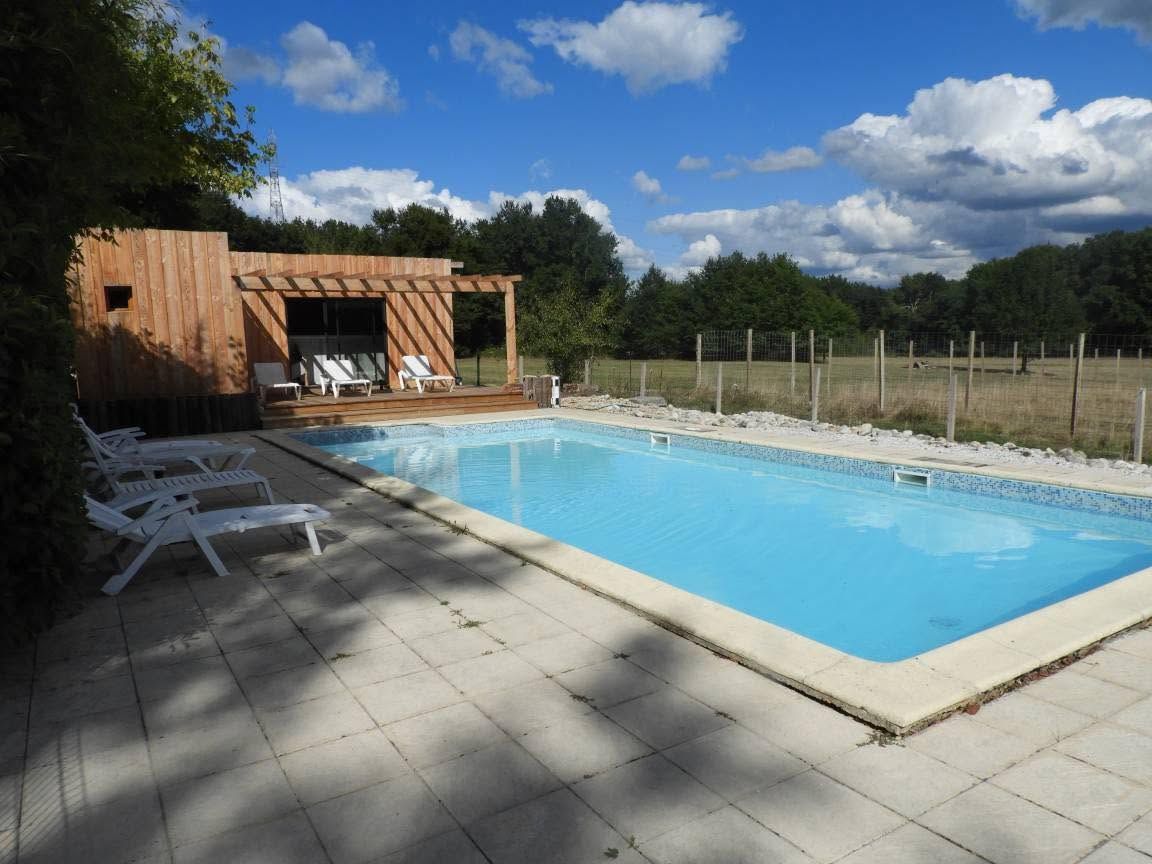 Ein Schwimmbad mit Liegestühlen und einer Holzkonstruktion.