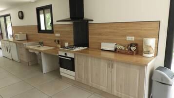 Una cocina moderna con una isla central, horno empotrado, microondas y cafetera.