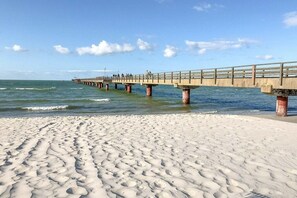 A pier extending into the sea with a sandy beach in the foreground. - Mühlenpark 1 W 1.2 "Crane Train" (Prerow)