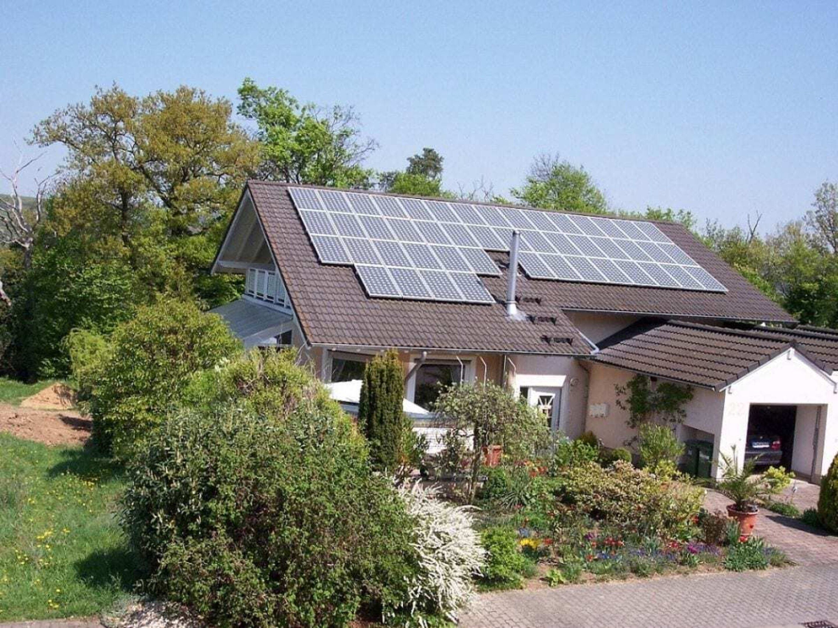 A house with a sloped roof and solar panels.