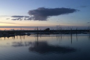 A calm water body with structures in the distance, possibly a marina or dock area. - Holiday apartment with 1 bedroom (Norddeich)