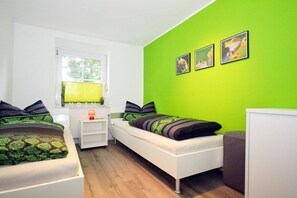 A bedroom with two beds, a window, and a green wall. - Holiday home in Norden with swimming pool (Norden)
