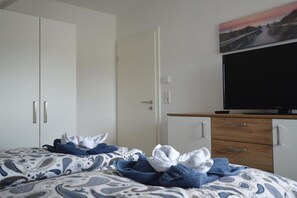 Ein Hotelzimmer mit Bett, Fernseher und Kleiderschrank.