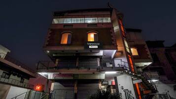 Un edificio de varios pisos con un letrero que indica 'TOWNHOUSE' y servicios 'YO-Serviced'.
