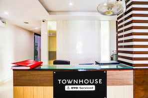 Una mesa de recepción con un cartel que indica que el servicio es proporcionado por OYO.