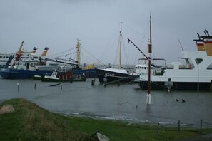 Un puerto con varias embarcaciones amarradas, incluyendo un barco blanco con el número 'HF476' en su lateral.