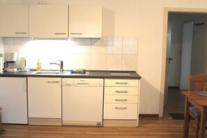 A compact kitchen with a dishwasher, a coffee maker, and a sink. - Baltic Sea dike (07) (Ostseebad Prerow)