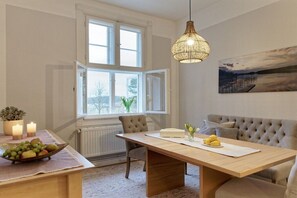 A dining area with a wooden table, chairs, a hanging light fixture, and a painting on the wall. - Holiday apartment with 2 bedrooms (Groß Zecher)