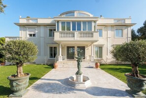 A large, two-story building with a symmetrical facade, a central entrance, and a fountain in the foreground. - Villa Bianca, just a few steps from the sea, with an exclusive garden and jacuzzi (Livorno)