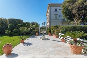 A paved pathway leading to a building with a white facade and a balcony. - Villa Bianca, just a few steps from the sea, with an exclusive garden and jacuzzi (Livorno)