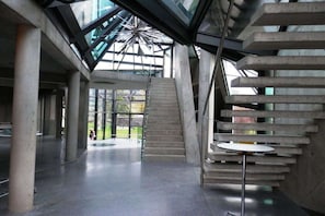 A modern interior with a central staircase, a glass ceiling, and a circular seating area. - Holiday apartment with 2 bedrooms (Bodensdorf)