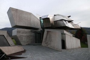 Um edifício moderno com estruturas de concreto angulares e entrada de vidro.