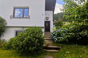 A white building with a black door and a window with a balcony. - Holiday apartment with 2 bedrooms (Bodensdorf)