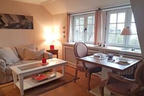 Ein gemütliches Wohnzimmer mit einer Couch, einem Couchtisch und einem Essbereich mit Tisch und Stühlen.