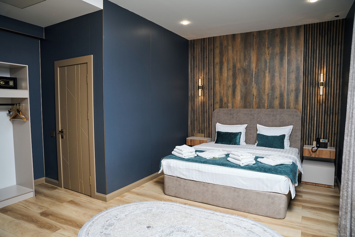 Un dormitorio moderno con cama, mesitas de noche, armario y alfombra redonda.