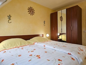 Ein Schlafzimmer mit einem Bett, einem Kleiderschrank und einem Spiegel.