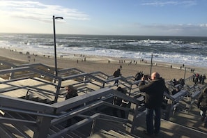 A beach with a wooden boardwalk and people walking. - Holiday apartment in Sylt with 1 bedroom (Wenningstedt)