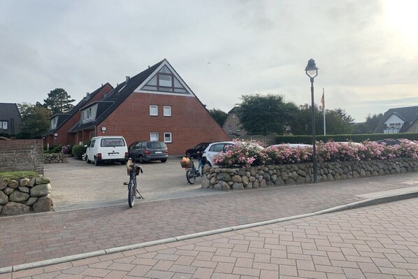 Ein Wohngebiet mit einem Haus, geparkten Autos und einem Fahrrad.