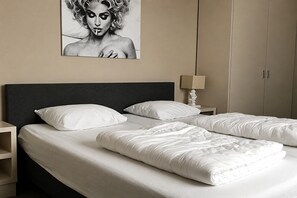 A hotel room with a large bed, two bedside tables, a nightstand, a lamp, and a wardrobe. - Luxury holiday home on Ameland (Nes)