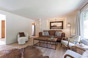A modern living room with a sofa, armchairs, a coffee table, and a rug. - A cozy getaway in a convenient location, offering a comfortable home base for exploring the city and surrounding Montana area. Enjoy a relaxing stay with easy access to local shops, dining, outdoor recreation, and all Missoula has to offer. (Missoula)