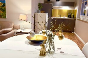 A dining table with a bowl, a vase with branches, and a small figurine. - I have a house by the lake, apartment 2 (Hohen Viecheln)