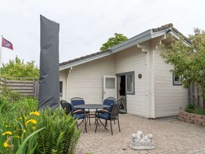 A small, single-story building with a covered patio area. - Holiday Home in Koudekerke With Wi-fi (Koudekerke)
