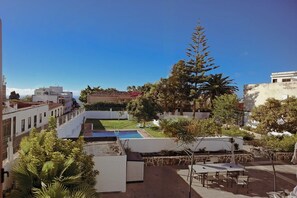 A rooftop terrace with a swimming pool, outdoor seating, and a view of surrounding buildings. - The individual Arona Mansion (Arona Casco)
