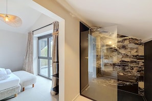 A modern bedroom with a large window, a bed, and a glass shower enclosure. - Family retreat in Belgium with sauna (Rochefort)