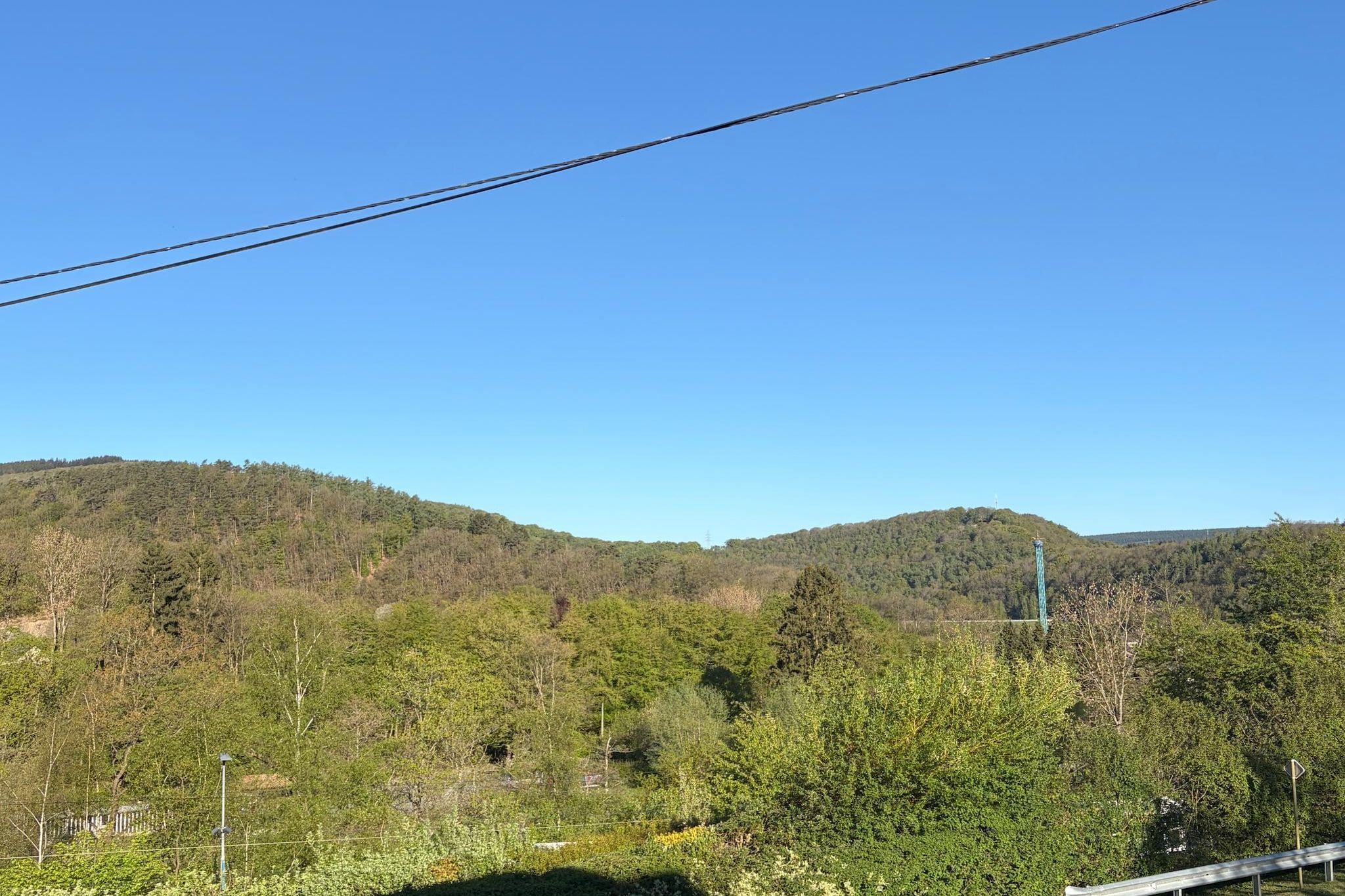 Eine gebirgige Landschaft mit dichtem Wald und blauem Himmel.
