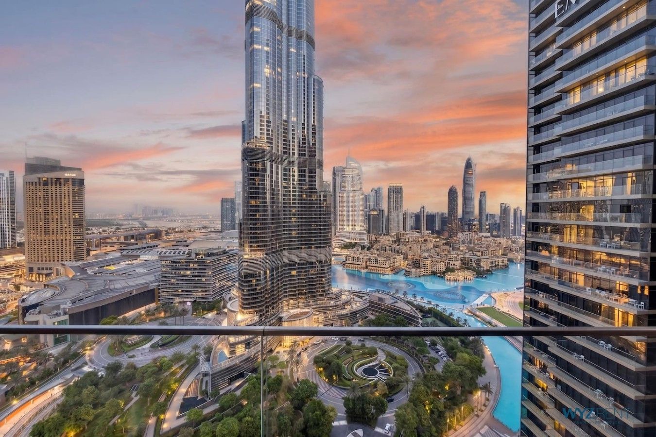 A high-rise building with a modern design, surrounded by other high-rise buildings and a body of water.