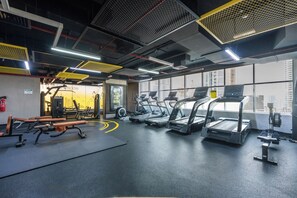 Ett gym med löpband, styrketräningsmaskiner och träningsmattor.