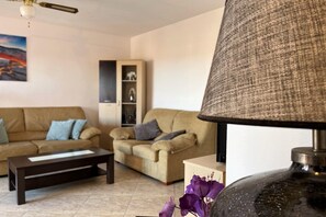A living room with a sofa, armchair, coffee table, and a lamp. - Coastal Family Apartment in Roquetas de Mar (Roquetas de Mar)