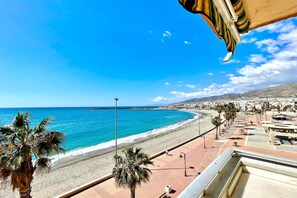 A coastal cityscape with a beach, palm trees, and a clear blue sky. - Beach Apartment for 5 in Adra (Adra)