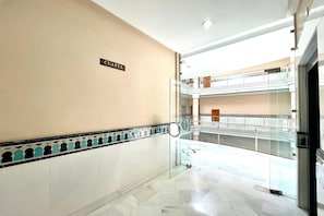 A hotel corridor with a 'CUARTA' sign, glass railings, and a tiled floor. - Central Granada Apartment for 4 (Granada)
