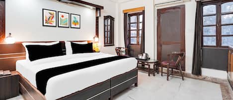 A bedroom with a bed, bedside tables, a desk, and a chair.