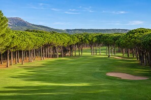 A golf course with a clear sky, a well-maintained green, and a distant mountain. - Romantic Apartment Getaway by the Beach (Pals)