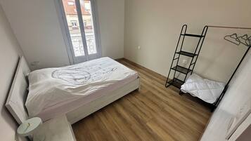 Ein Zimmer mit einem Bett, einem Fenster, einem Etagenbett und einem Nachttisch.
