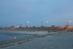 A beach with a fence, benches, and a small structure. - Holiday home with 4 bedrooms (Dornum-Nessmersiel)