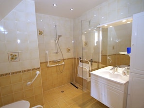 Ein Badezimmer mit Dusche, Toilette und Waschbecken.