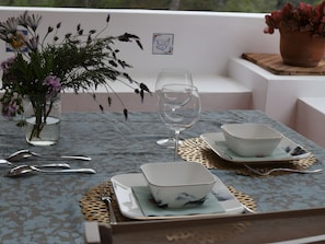 A table set with a glass, two bowls, a spoon, and a vase with flowers. - Villa Bohemia: Sea View, Private Pool, and Wi-Fi (Olivella)