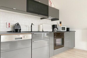 A modern kitchen with stainless steel appliances, a microwave, a coffee maker, and a toaster. - Holiday apartment with 2 bedrooms (Timmendorfer Strand)