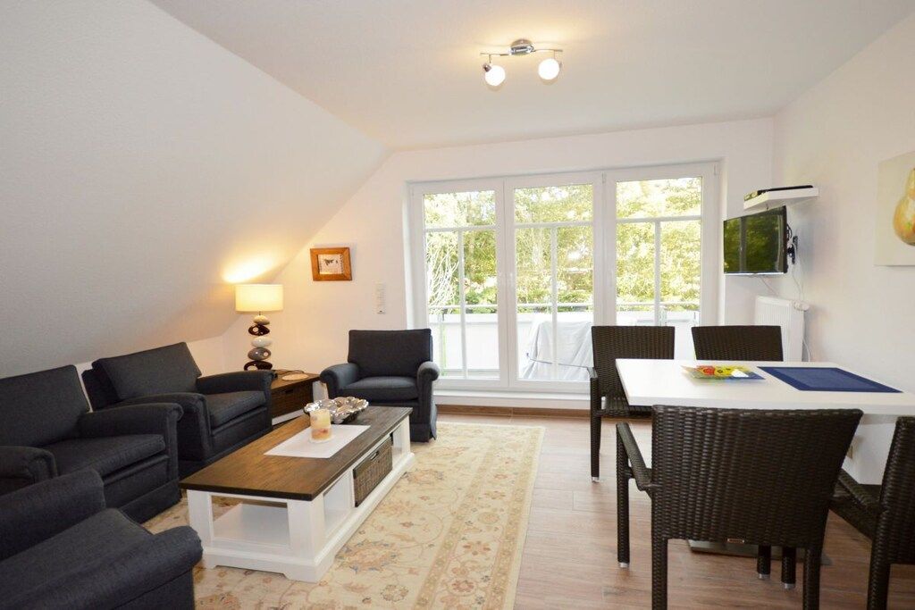 Ein modernes Wohnzimmer mit einer Sofagarnitur, einem Couchtisch und einem Essbereich mit Stühlen und einem Tisch.