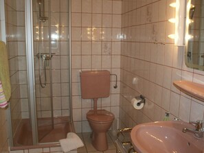A bathroom with a glass-enclosed shower, a toilet, and a sink. - Holiday Apartment With 2 Bedrooms (Walsrode)