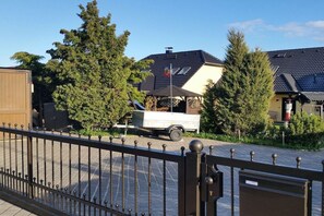A gated driveway leading to a house with a trailer parked in front. - near Warnemünde (Rostock) (Admannshagen-Ausbau)